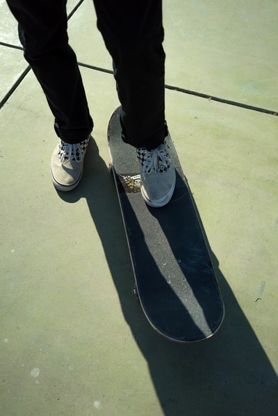 person in black pants and white and blue sneakers